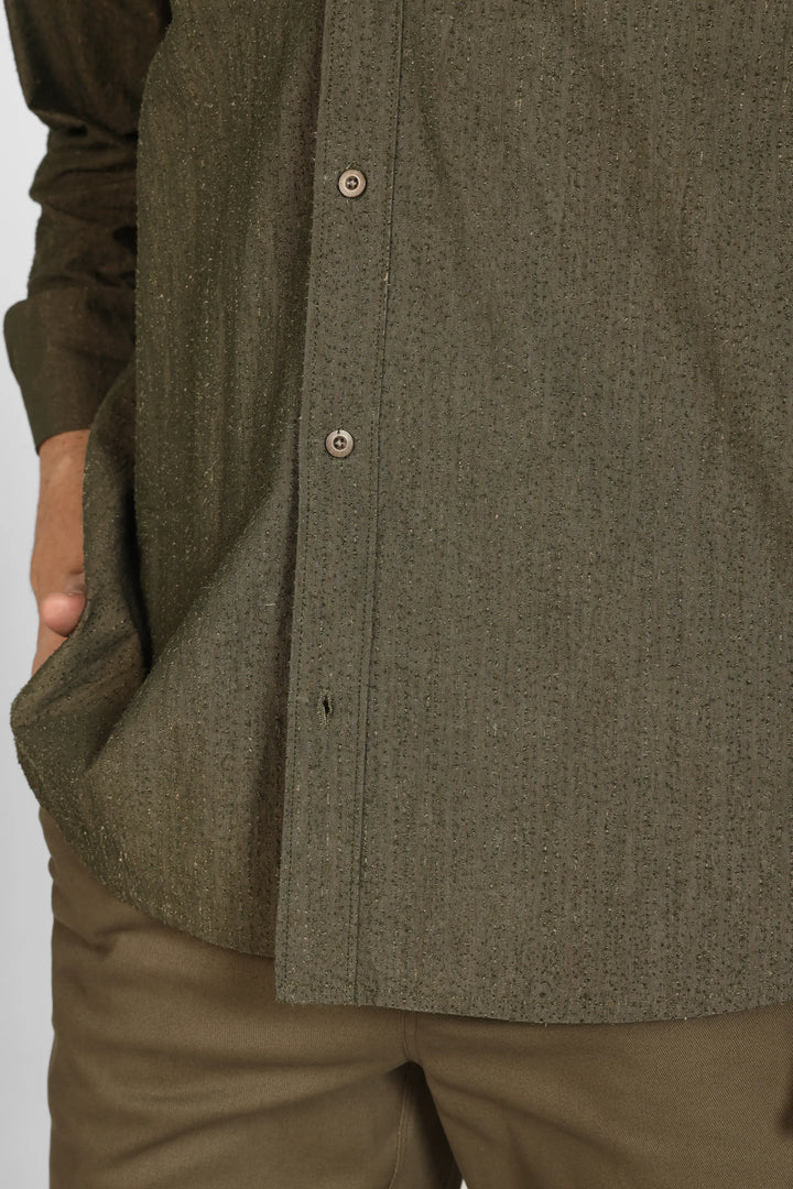 Close-up of a person wearing a Olive Grain Cotton Shirt and pants on a white background