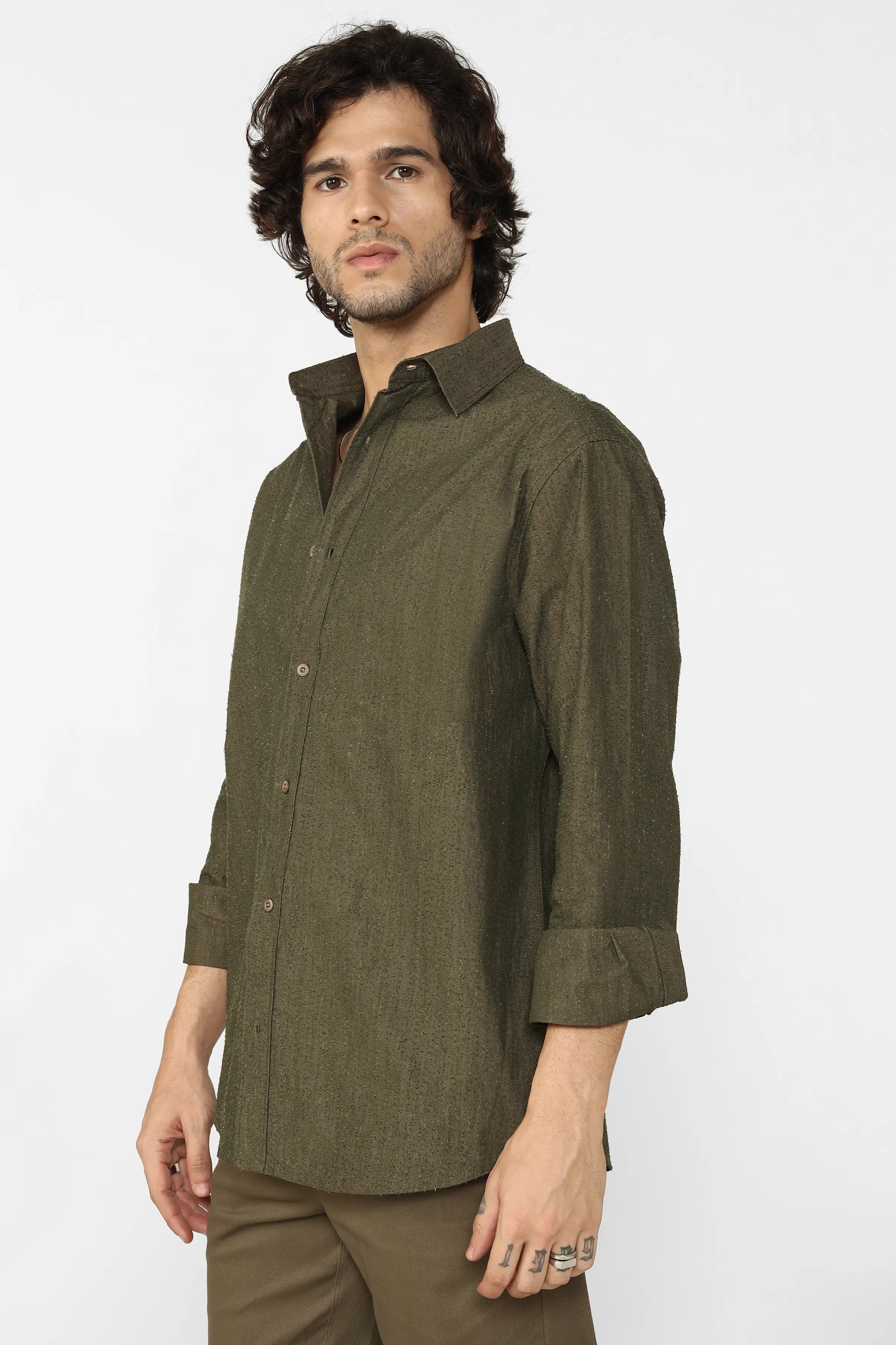 Man wearing an olive green shirt and pants on a white background