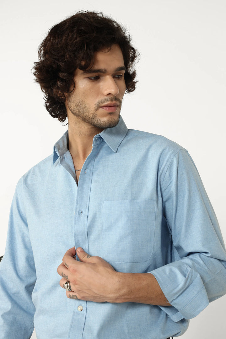 Man wearing a light blue shirt against a plain background