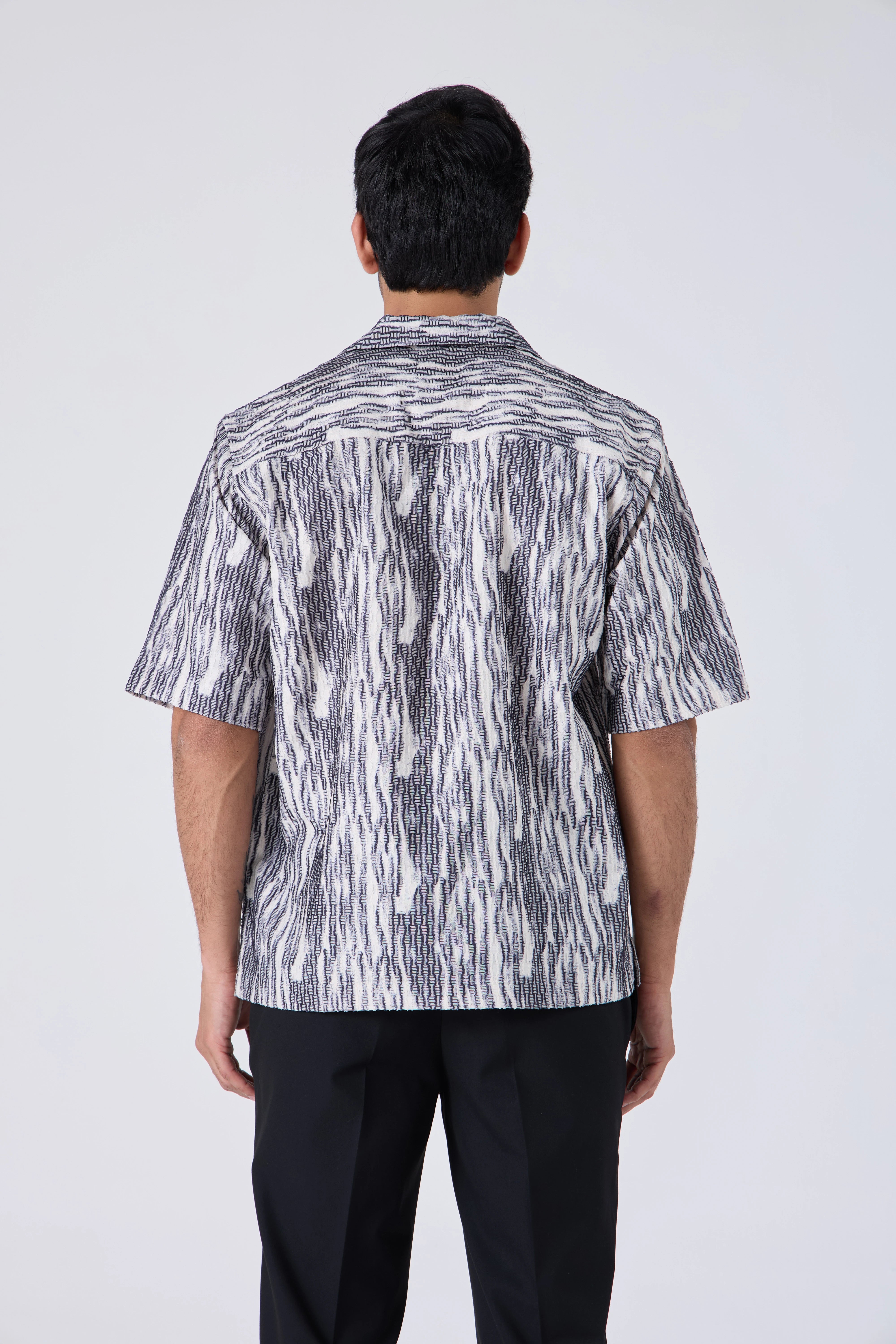Person wearing a FLOWING ABSTRACT SHIRT - CRAIG and black pants on a white background