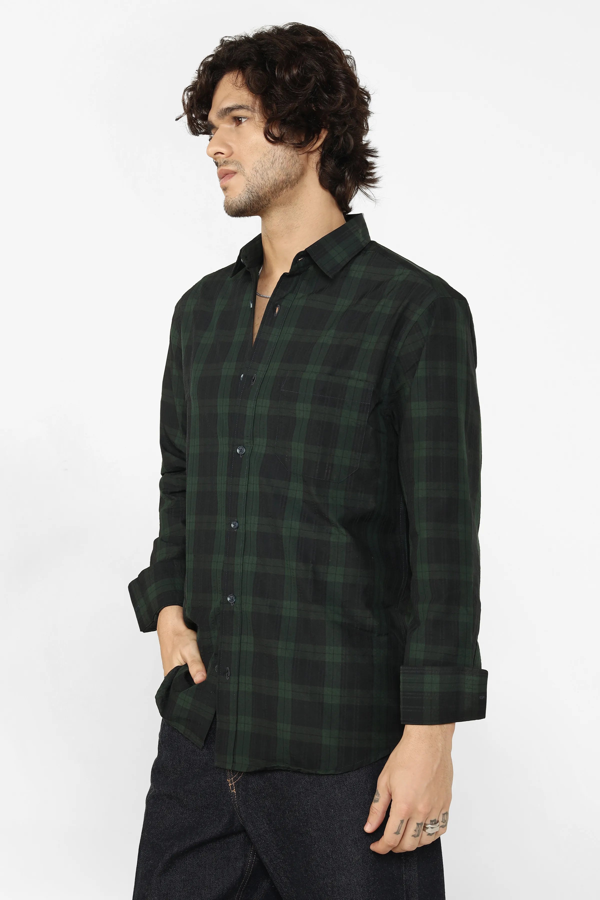 Man wearing a dark green plaid shirt on a white background