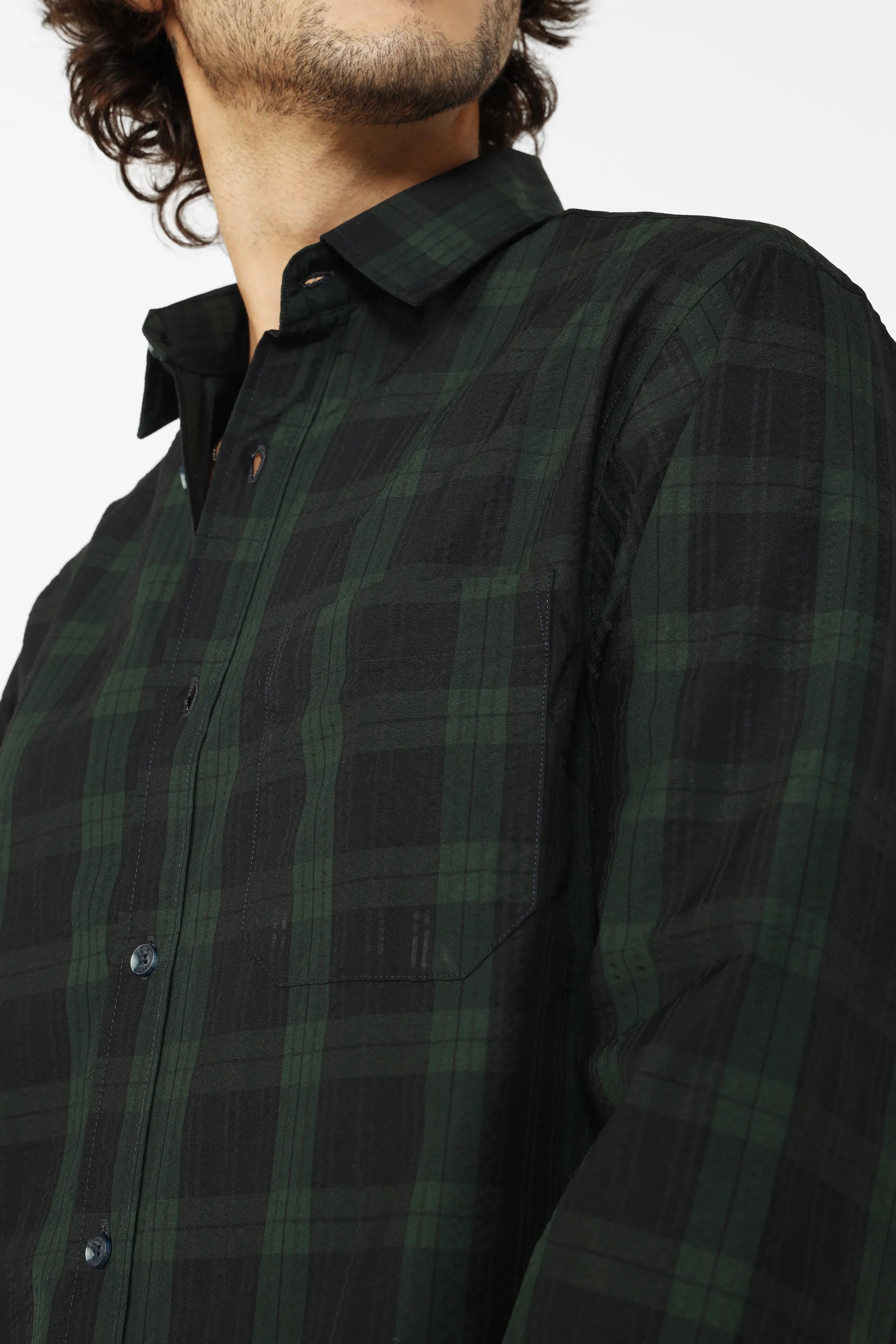 Green seersucker shirt worn by a person on a white background