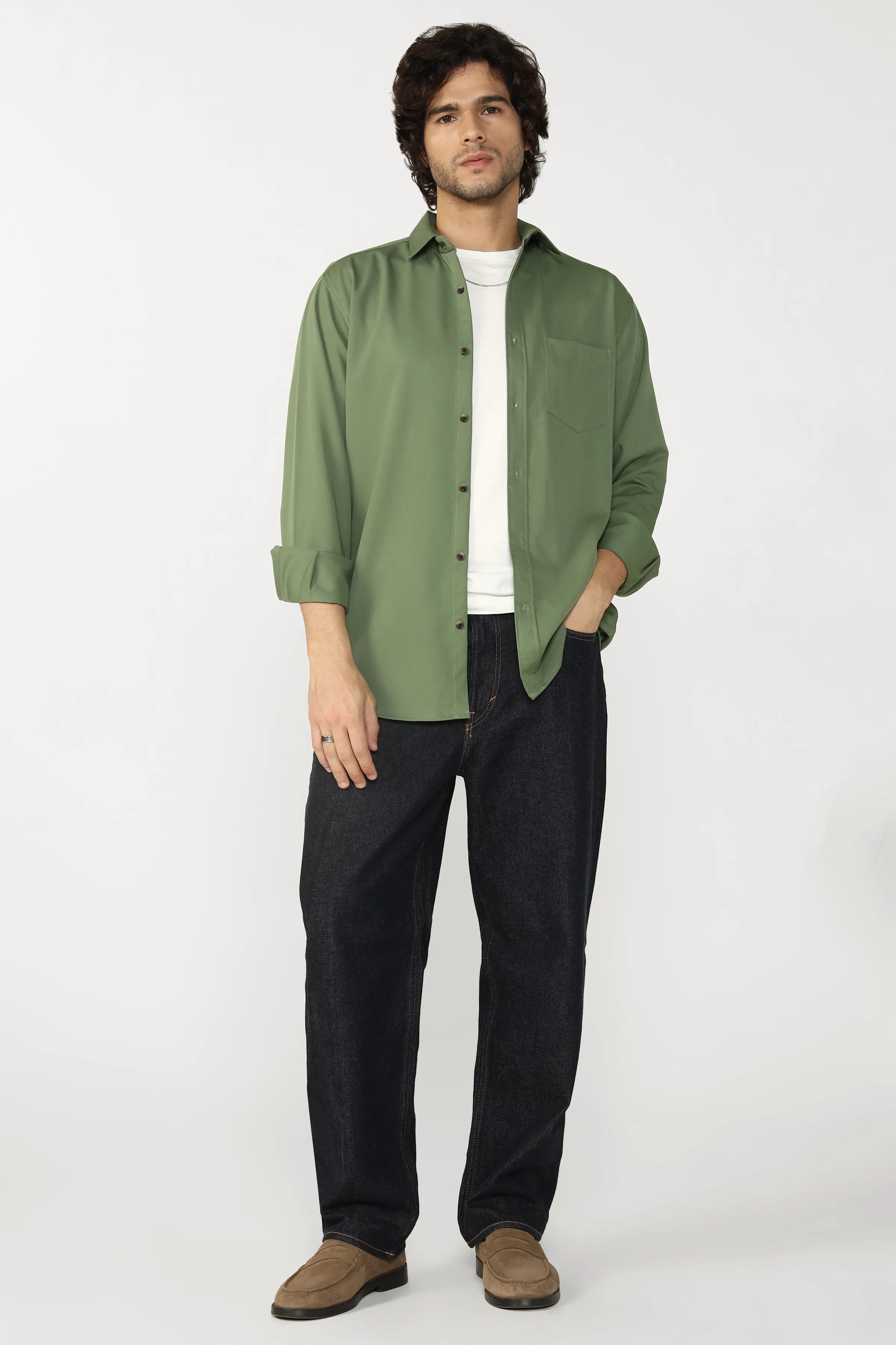 Man wearing a jade cotton shirt over a white t-shirt with black pants on a white background