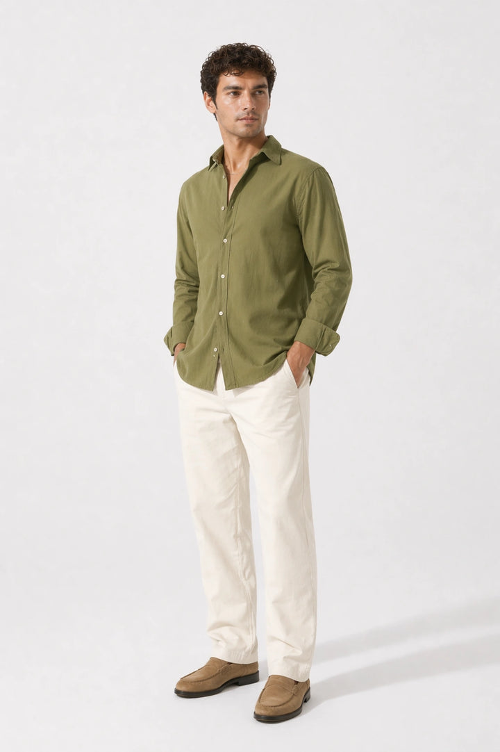 Man wearing a olive shirt and white pants on a white background