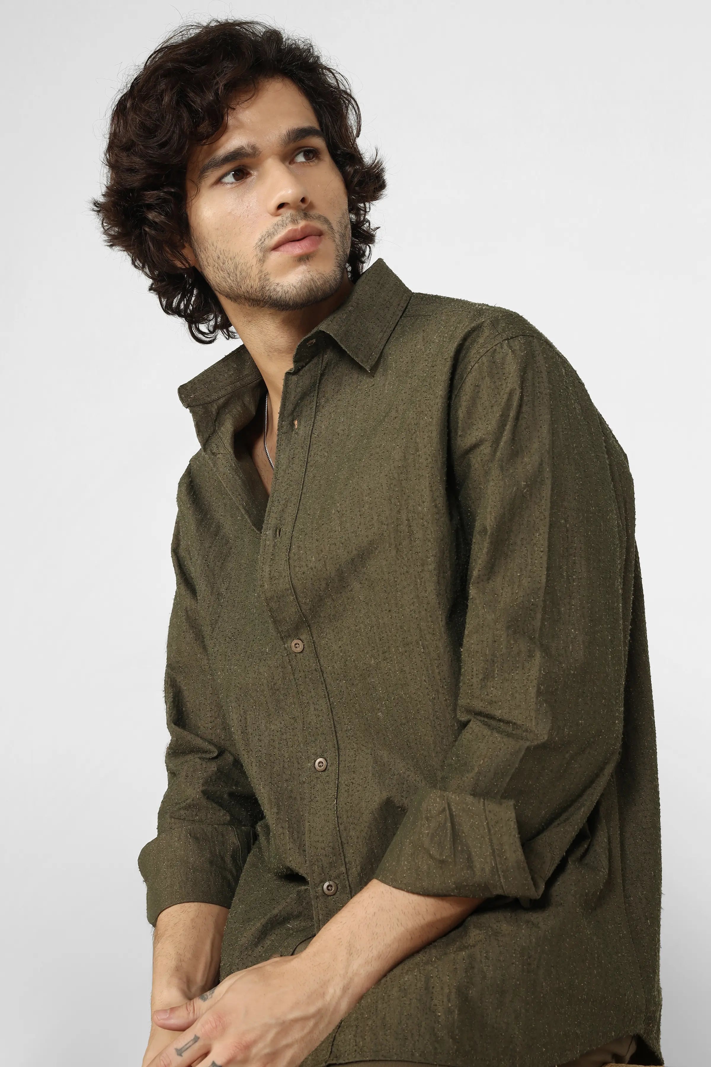 Man wearing a green shirt against a white background