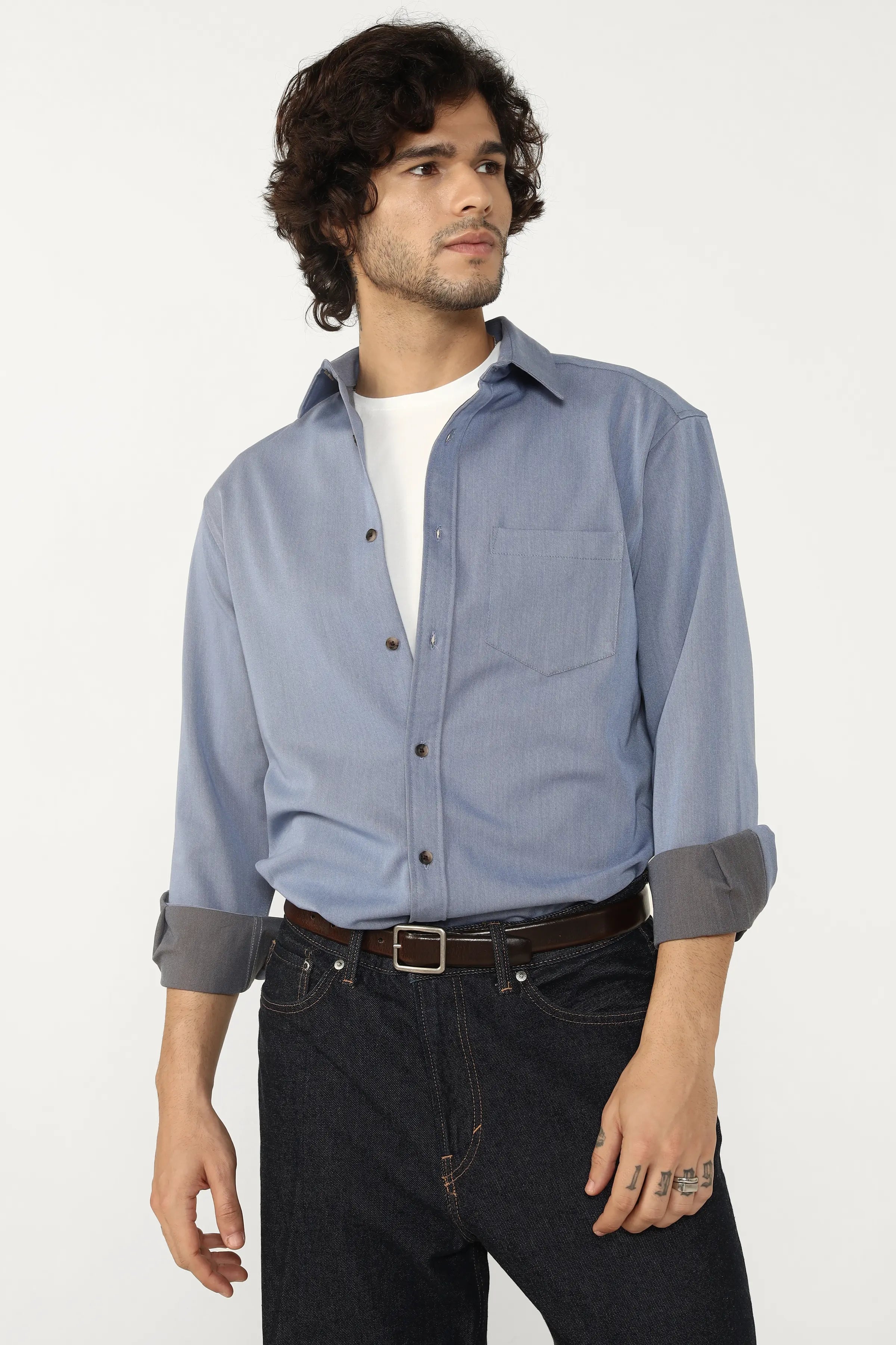 Man wearing a Oxford Cotton Twill button-up shirt and dark jeans on a white background