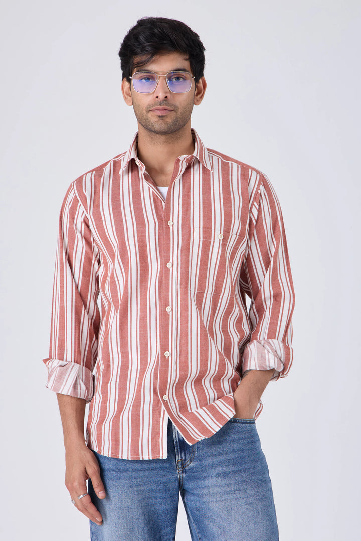 Man wearing a tan cotton striped shirt with rolled-up sleeves against a plain background