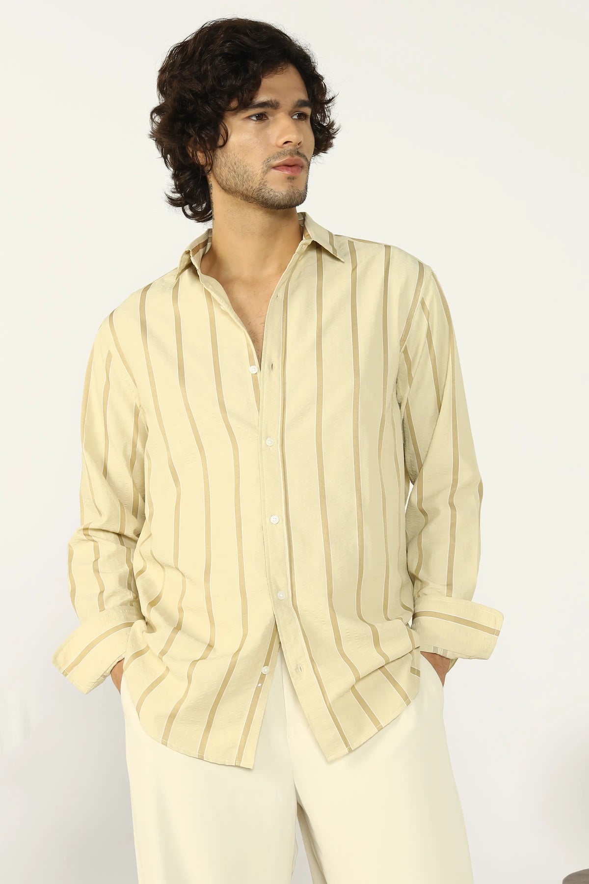 Man wearing a yellow seersucker striped shirt and pants against a white background